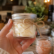 Hand holding a 125ml glass jar of whipped body butter for The Green Goddess Stocking Stuffer Workshop